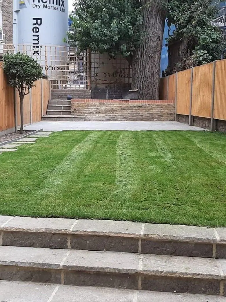 The same garden after Ogival rebuilt it: retaining wall, steps, paving, new fencing and lawn